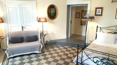 a bedroom with a bed and a chair and a lamp at Paola A Trastevere in Rome