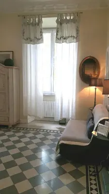 a bedroom with a bed and a window with curtains at Paola A Trastevere in Rome