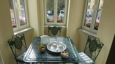 a table and chairs in a room with windows at Paola A Trastevere in Rome