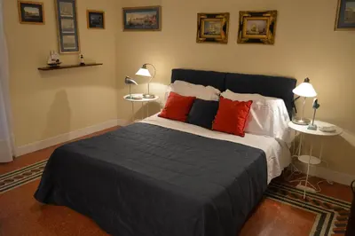a bedroom with a bed with red pillows and two lamps at Paola A Trastevere in Rome
