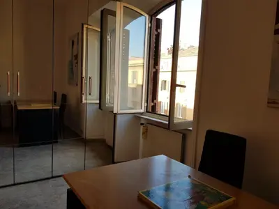 a room with a wooden table and a window at Napoleone's House in Rome