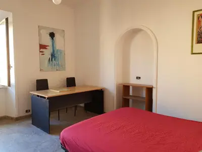 a bedroom with a desk and a red bed at Napoleone's House in Rome