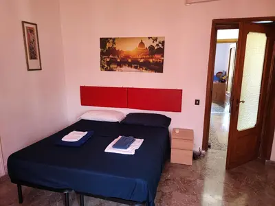 a bedroom with a blue bed with a red headboard at Napoleone's House in Rome