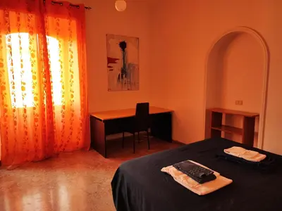 a bedroom with a bed and a desk and a window at Napoleone's House in Rome