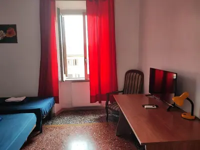 a room with a bed and a desk and a window at Napoleone's House in Rome