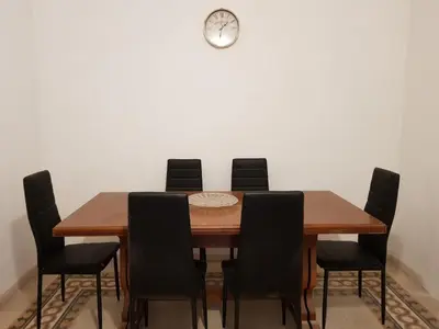a dining room table with chairs and a clock on the wall at Napoleone's House in Rome