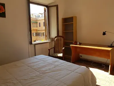 a bedroom with a bed and a desk and a window at Napoleone's House in Rome