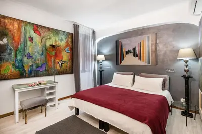 a bedroom with a bed with a large painting on the wall at Spanish Steps Art Gallery- Roma in Rome
