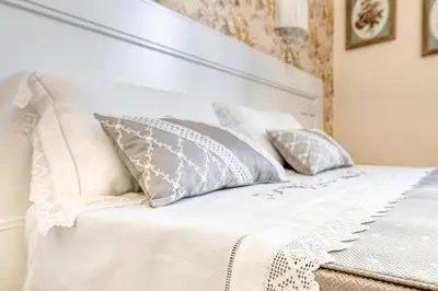 a white bed with pillows on top of it at Luxury Stars In Rome - Andromeda apartment in Colosseum in Rome