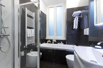 a bathroom with a tub and a toilet and a sink at Relais de l'Opera Luxury Rooms in Rome