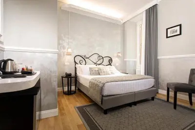 a bedroom with a bed and a desk and a chair at Relais de l'Opera Luxury Rooms in Rome