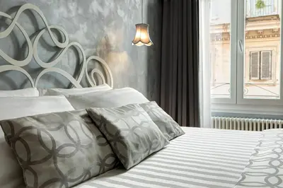 a bedroom with a bed with a large headboard at Relais de l'Opera Luxury Rooms in Rome