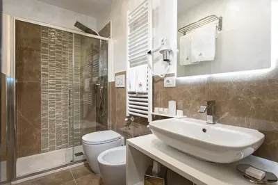 a bathroom with a sink and a toilet at Relais de l'Opera Suites in Rome