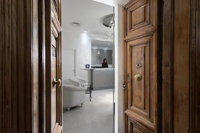 a hallway with a door and a woman in the background at Relais de l'Opera Suites in Rome