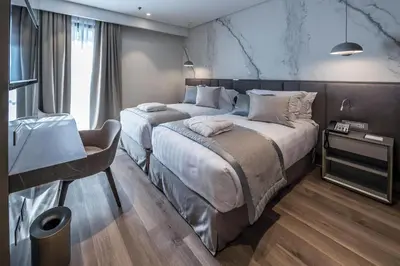 a bedroom with two beds and a desk in it at The Regency, Rome, a Tribute Portfolio Hotel in Rome