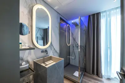 a bathroom with a shower and a sink and a mirror at The Regency, Rome, a Tribute Portfolio Hotel in Rome