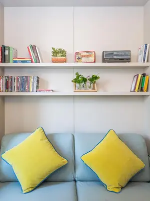 a blue couch with two yellow pillows in a room at Casa Epiro in Rome
