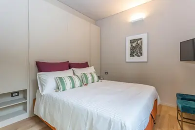 a bedroom with a white bed and a television at Casa Epiro in Rome