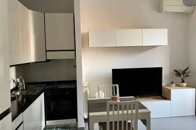 a kitchen with white cabinets and a table and a tv at Central modern apartment Rome -Locazione Turistica- in Rome
