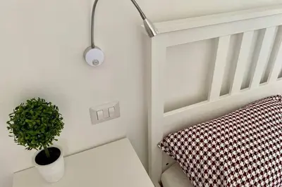 a plant sitting on a table next to a bed at Central modern apartment Rome -Locazione Turistica- in Rome