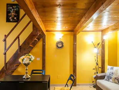a dining room with yellow walls and a wooden ceiling at Wood Easy Flat in Rome