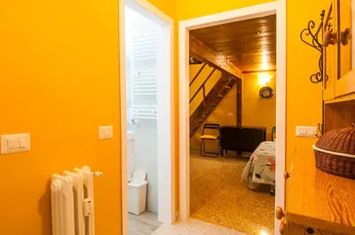 a hallway with a room with yellow walls and a staircase at Wood Easy Flat in Rome