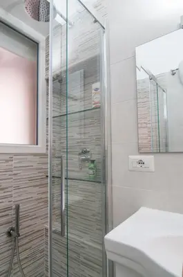 a glass shower in a bathroom with a sink at Wood Easy Flat in Rome