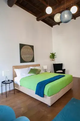 a bedroom with a large bed and a chair at Palazzetto de Lante Appartamento Parione in Rome