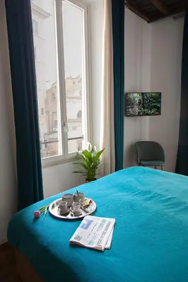 a hotel room with a blue bed and a window at Palazzetto de Lante Appartamento Parione in Rome