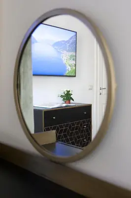 a mirror reflecting a dresser with a tv on a wall at Palazzetto de Lante Appartamento Parione in Rome