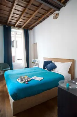 a bedroom with a large bed with a blue blanket at Palazzetto de Lante Appartamento Parione in Rome