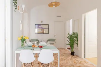 a white dining room with a table and white chairs at iFlat Lovely Apartment for Groups in Rome