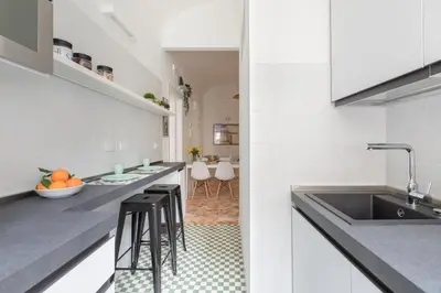 a kitchen with a sink and a counter with stools at iFlat Lovely Apartment for Groups in Rome