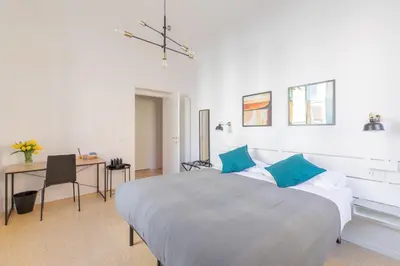 a white bedroom with a large bed and a desk at iFlat Lovely Apartment for Groups in Rome