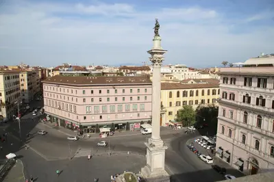 a large pole with a statue in the middle of a city at Biancorè in Rome