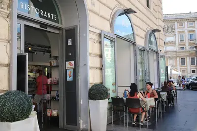 two women sitting at a table outside of a restaurant at Biancorè in Rome