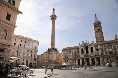 a large pole in the middle of a city with buildings at Biancorè in Rome