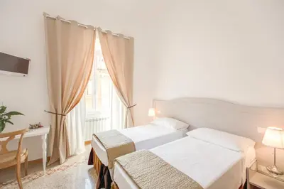a hotel room with two beds and a window at Biancorè in Rome