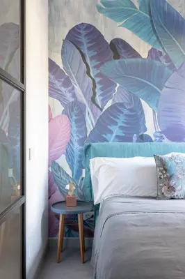 a bedroom with a bed with a mural of leaves at Twin Flowers apartment in San Giovanni in Rome