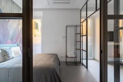 a bedroom with a bed and a glass wall at Twin Flowers apartment in San Giovanni in Rome