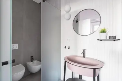 a bathroom with a pink sink and a mirror at Twin Flowers apartment in San Giovanni in Rome