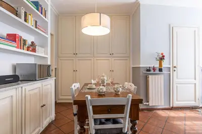 a kitchen with a table with chairs and a microwave at Rome As You Feel - Paradiso Apartment in Rome