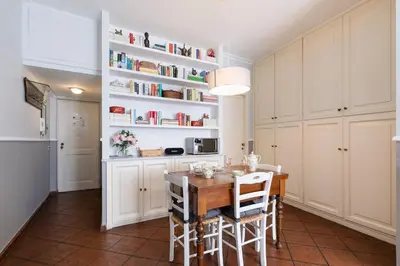 a kitchen with a table and chairs and bookshelves at Rome As You Feel - Paradiso Apartment in Rome