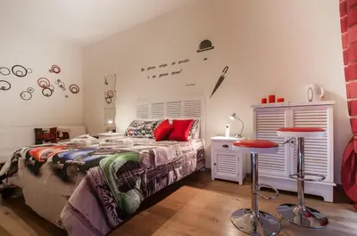 a bedroom with a bed and two bar stools at Demi's home in Rome