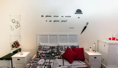 a bedroom with a bed with a quote on the wall at Demi's home in Rome
