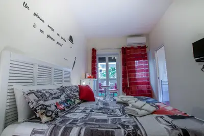 a bedroom with a large bed with a red curtain at Demi's home in Rome