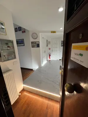 a hallway with a room with a clock on the wall at EMI's Guest House in Rome