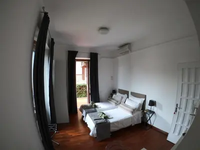 a bedroom with a bed and a couch and a window at EMI's Guest House in Rome