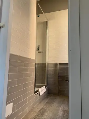 a bathroom with a mirror and a walk in shower at EMI's Guest House in Rome