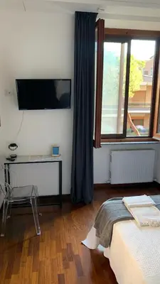 a bedroom with a bed and a television on a wall at EMI's Guest House in Rome